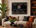 A framed wall art print featuring an African proverb on a black background with geometric border patterns, displayed above a beige sofa in a styled living room.